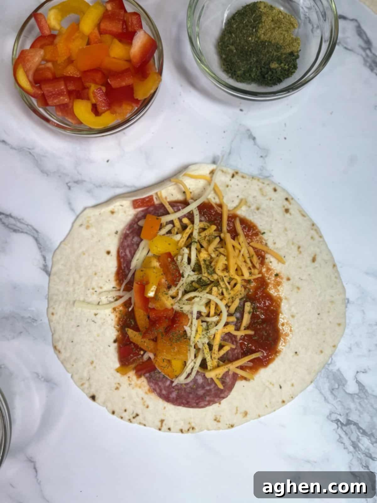 Snack Goals: Baked Pizza Burritos 4 A low-carb tortilla laid flat with a layer of pizza sauce, pepperoni, and cheese, ready to be folded into a pizza burrito.