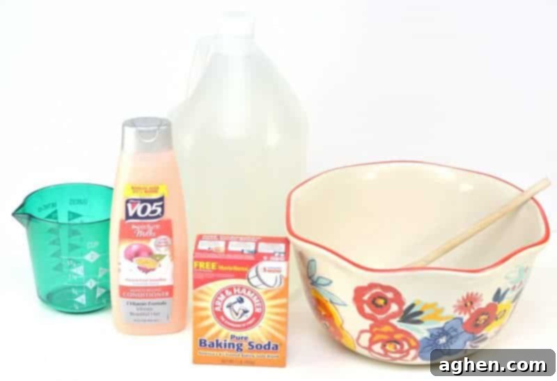 Ingredients for homemade fabric softener: hair conditioner, white vinegar, baking soda, and hot water in a measuring cup, neatly laid out on a kitchen counter.