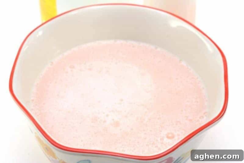The finished homemade fabric softener mixture resting in a bowl, with fewer bubbles, ready for storage.