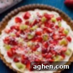 A beautifully decorated no-bake fruit pizza with cream cheese and fresh fruit on top of a homemade graham cracker crust, perfect for summer.