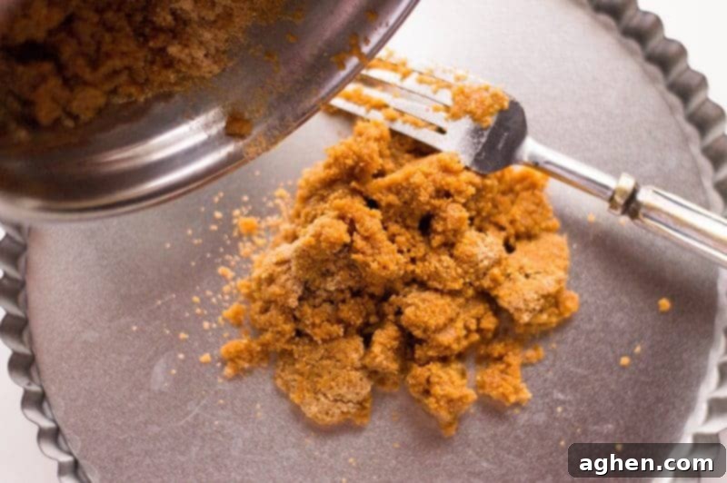 Mixing graham cracker crumbs with melted butter for the no-bake fruit pizza crust.