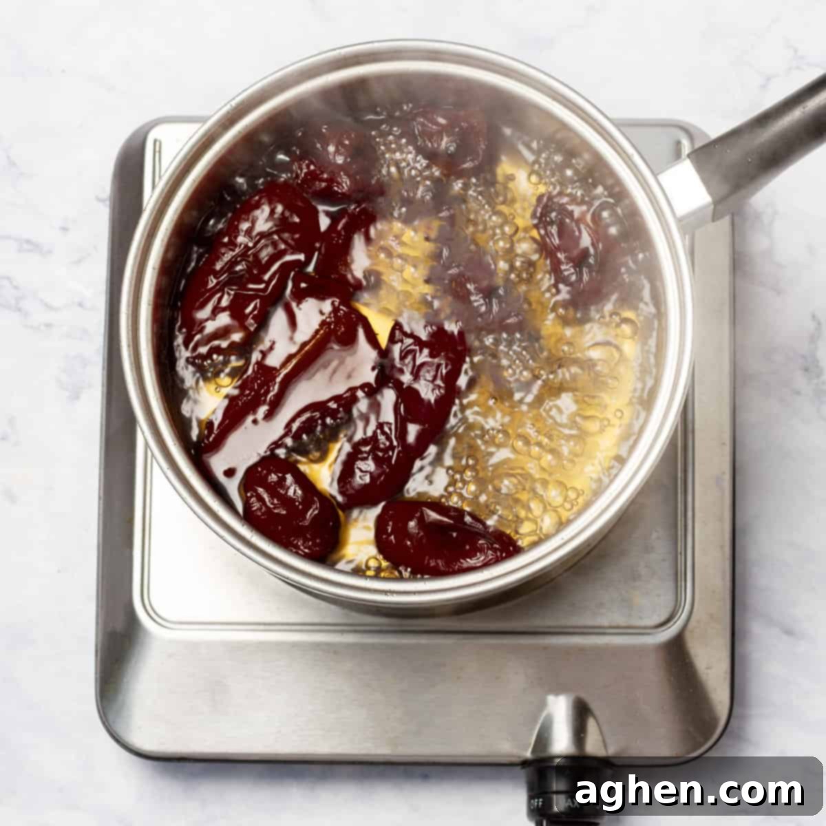 Morita chilies simmering in water in a medium saucepan