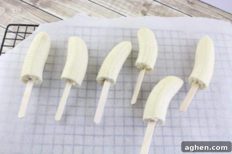 Halved bananas expertly placed on popsicle sticks, ready for dipping.