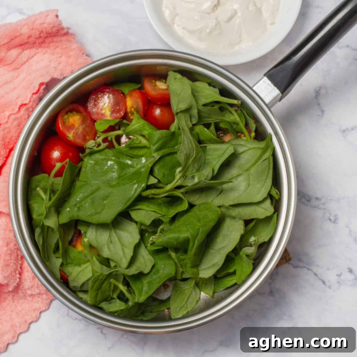 Spinach and cherry tomatoes sautéeing with chicken breasts. 