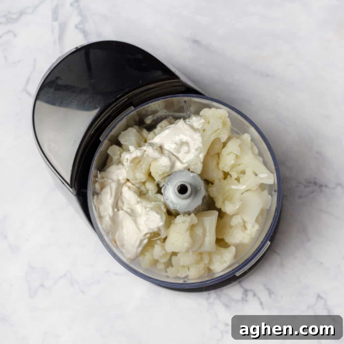 The Zero Point Mashed Cauliflower I Make On Repeat 5 Cooked cauliflower florets, plain yogurt, skimmed milk, and minced garlic placed inside a food processor, ready to be blended.