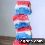 A perfectly set piece of Red, White, and Blue Fudge, showcasing the distinct layers of patriotic colors. This easy no-bake dessert is a must-try for your 4th of July celebration.