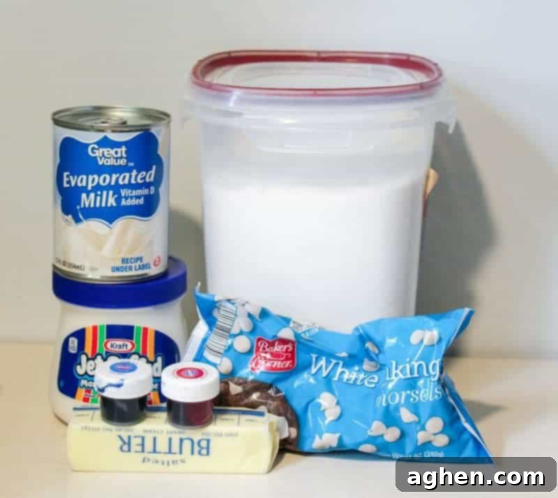 A flat lay of ingredients for Red White and Blue Fudge: Marshmallow creme, butter sticks, granulated sugar, bottles of red and blue gel food coloring, white chocolate chips, and a can of evaporated milk.