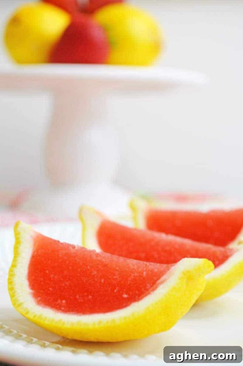 Strawberry lemonade jello shots in lemon wedges, ready to be sliced.