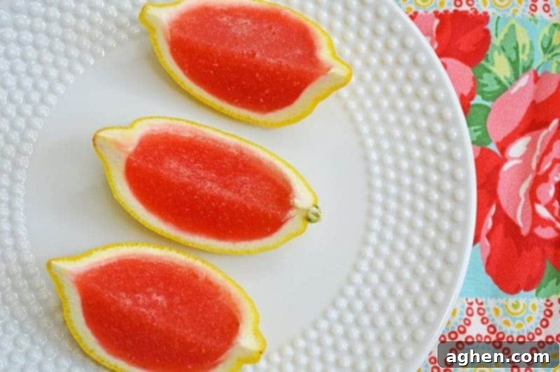 Finished strawberry lemonade jello shots made with vodka and served in lemon wedges.