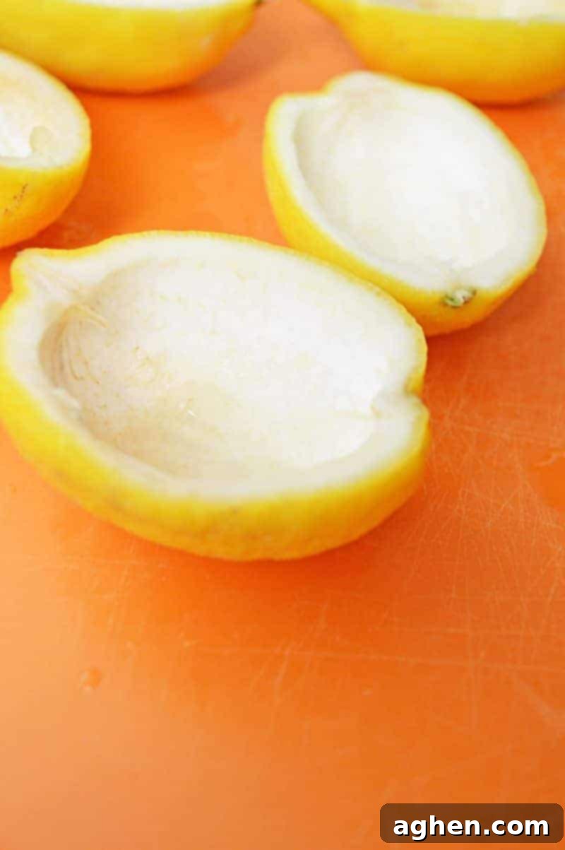 Hollowing out lemon halves with a spoon for jello shots.