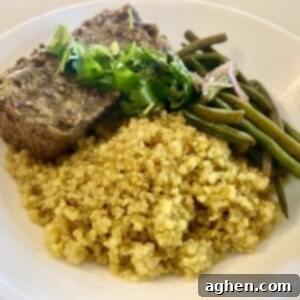 Hearty and flavorful Vegan Lentil Loaf on a plate with green beans and quinoa.