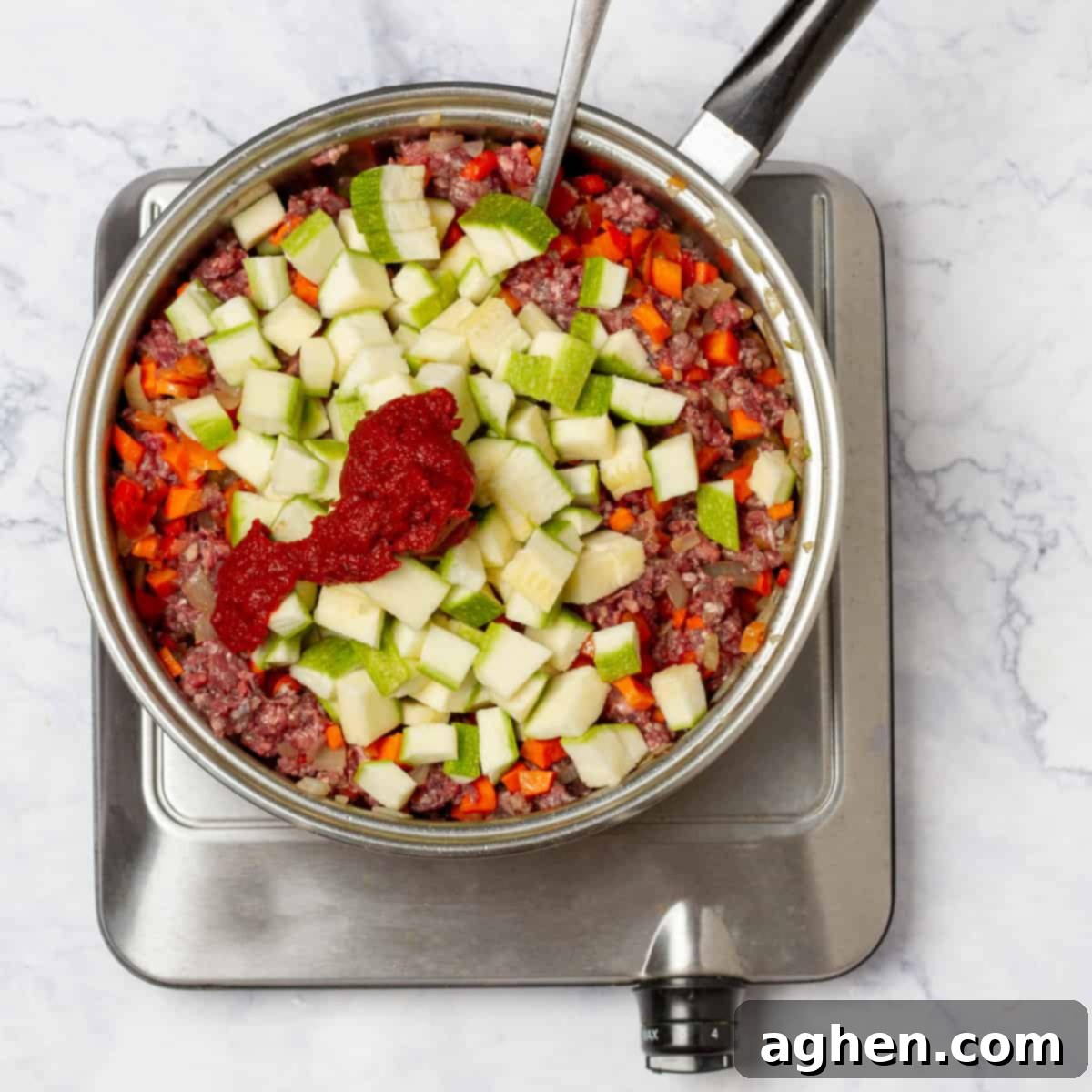 Warm Up Cold Nights with a Hearty Beef Pie 6 Ground beef and chopped vegetables cooking together in a hot skillet, forming the savory pie filling.