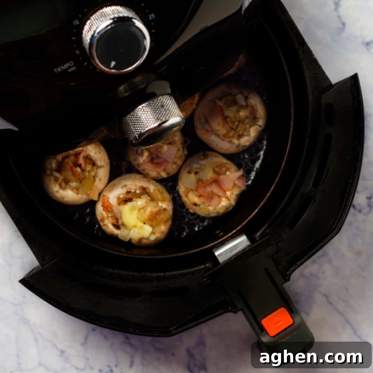 Guilt-Free Stuffed Mushrooms 7 Stuffed mushroom caps cooking in the air fryer.