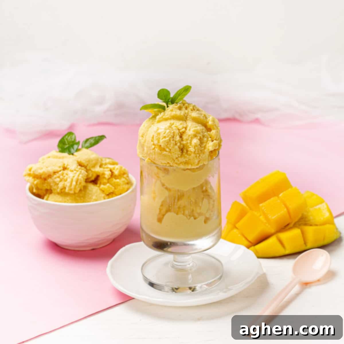 Tropical Mango Coconut Delight 2 Creamy Mango and Coconut Ice Cream served in a bowl and glass with mango slices, garnished with mint.