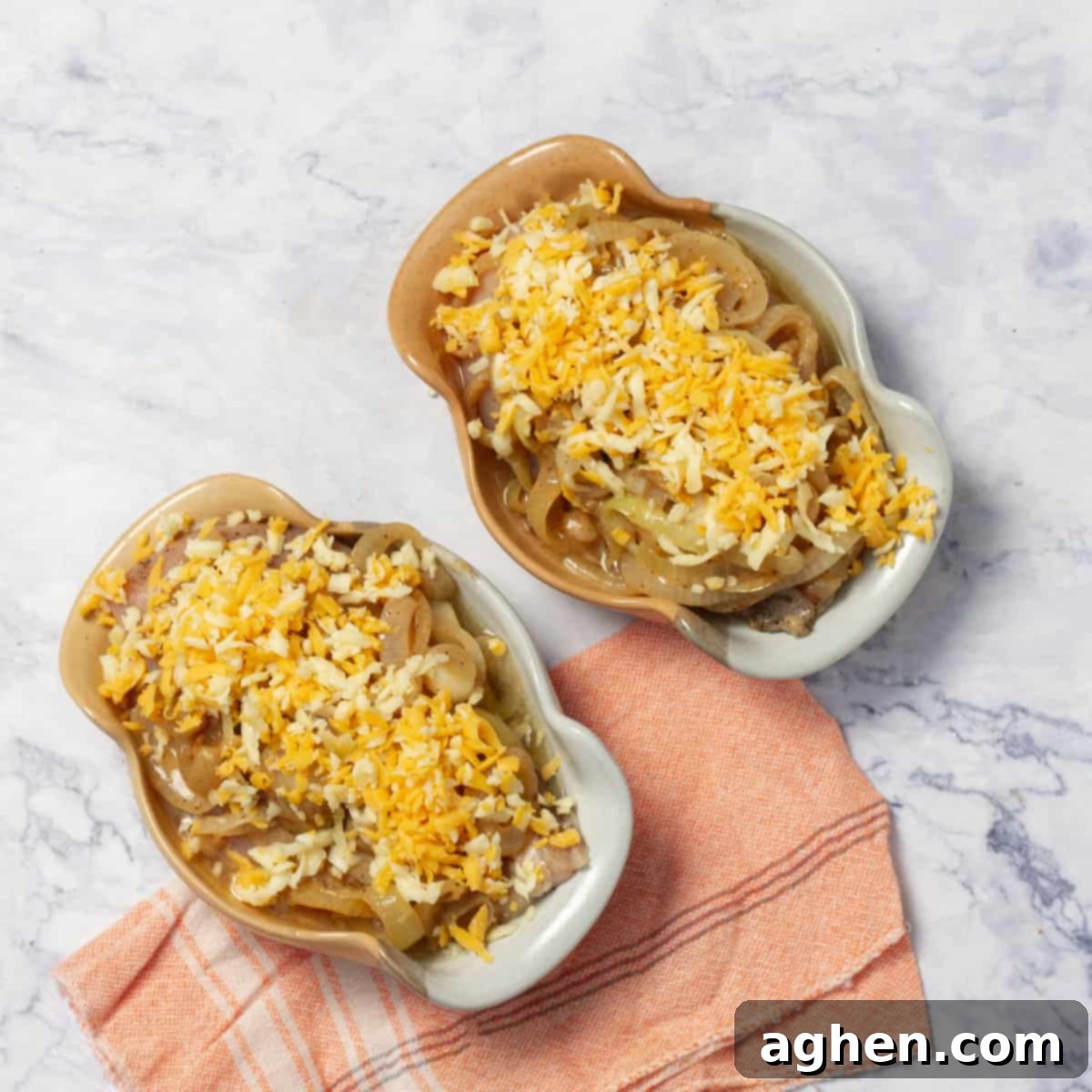 seasoned chicken supremes in a casseroles with the caramelized onions and cheese