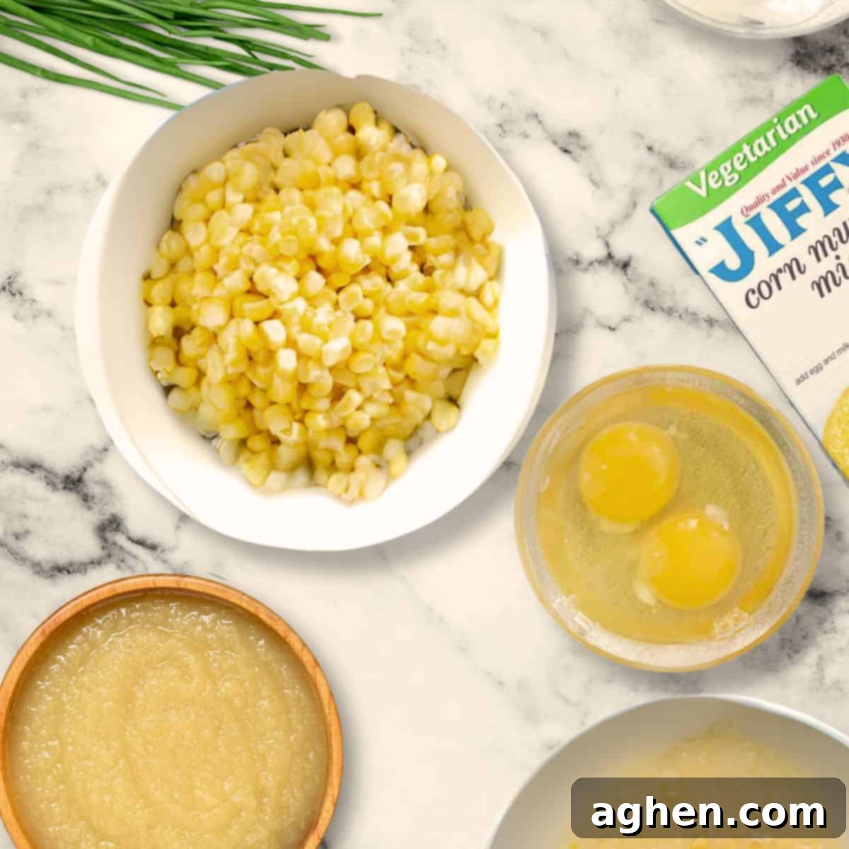 My Weight Watchers Jiffy Corn Casserole Recipe 3 A colorful array of ingredients for Jiffy corn casserole: Jiffy mix, canned corn, Greek yogurt, applesauce, green onions, and cheese.