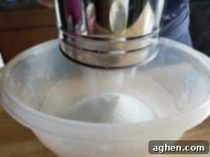 Sift dry ingredients to remove lumps for a smooth bath bomb mixture.