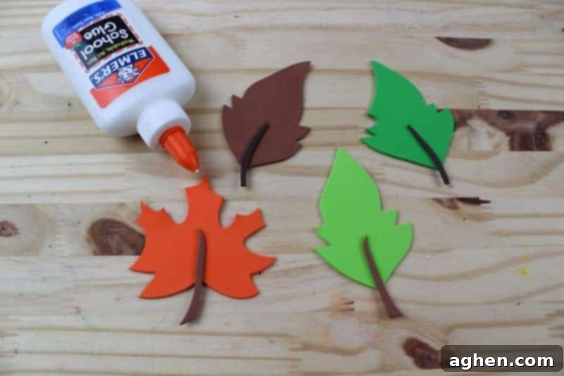 Step 5: Glue small brown stems onto the base of each individual craft foam leaf, adding detail.