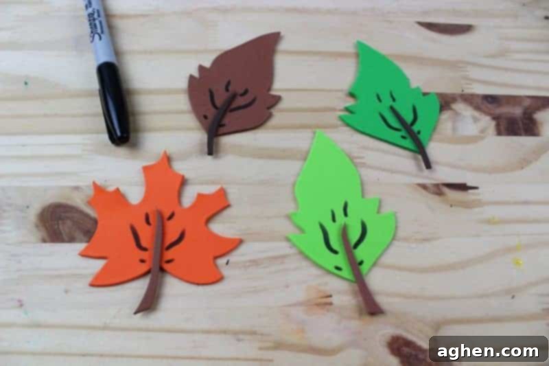 Step 6: Draw intricate veins on the craft foam leaves using a black marker for a realistic and artistic touch.