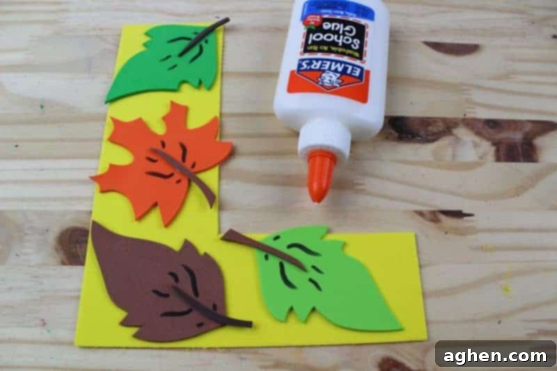 Step 7: Glue the beautifully decorated leaves onto the large letter L cutout to complete the 'L is for Leaf' craft.