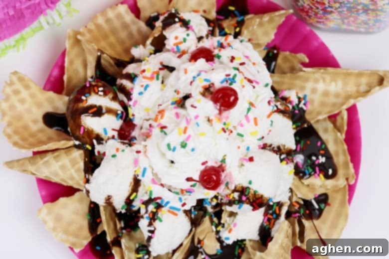 Delicious ice cream nachos sundae featuring vanilla ice cream, generous whipped cream, colorful sprinkles, rich chocolate syrup, and bright red maraschino cherries.