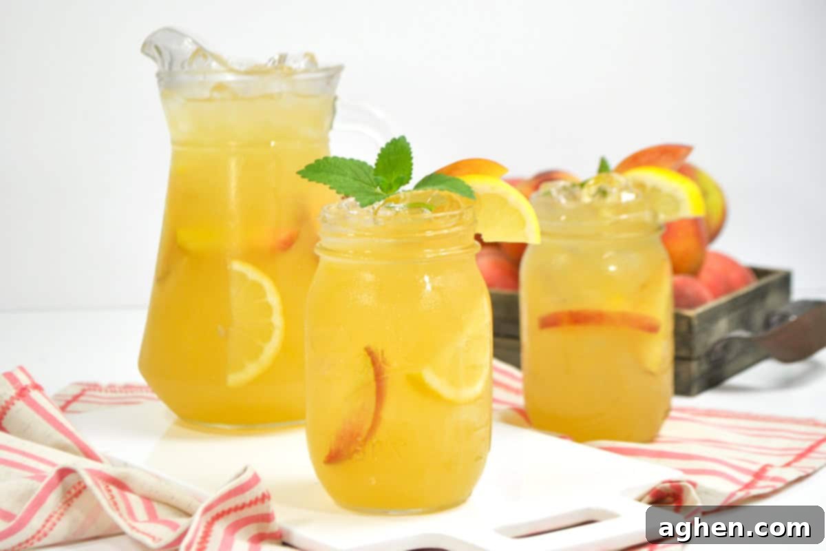 Sun Drenched Peach Lemonade 3 A mason jar of homemade peach lemonade with lemon and peach slices, garnished with mint and lemon.