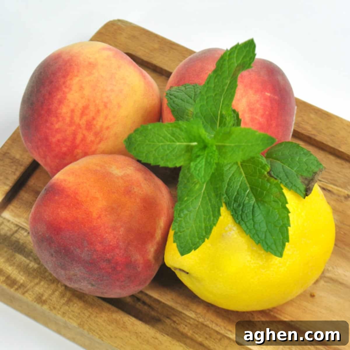 Sun Drenched Peach Lemonade 4 Fresh peaches, a lemon, and mint sprig on cutting board.