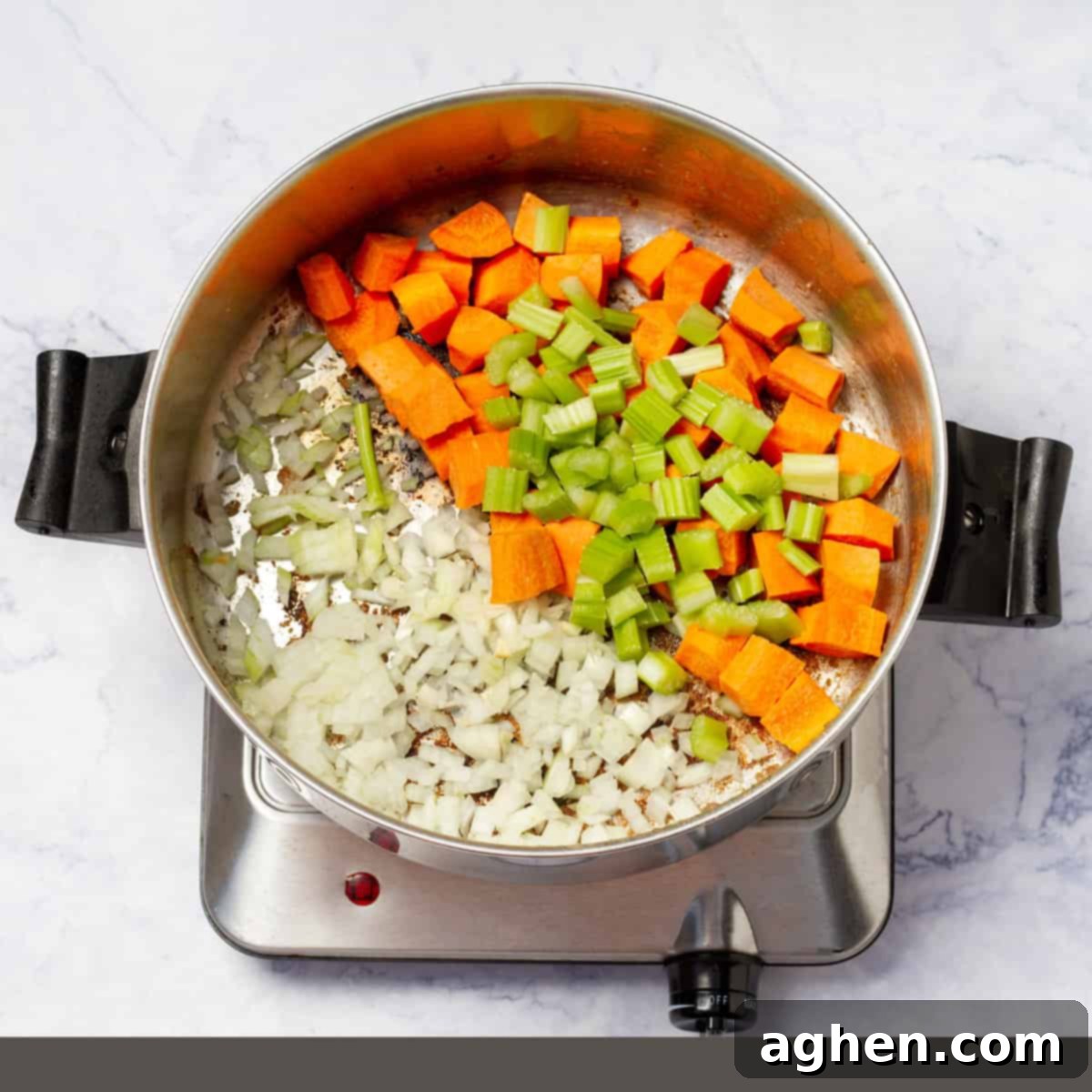 Diced zucchini, carrots, beef, and onions prepped for cooking in a saucepan
