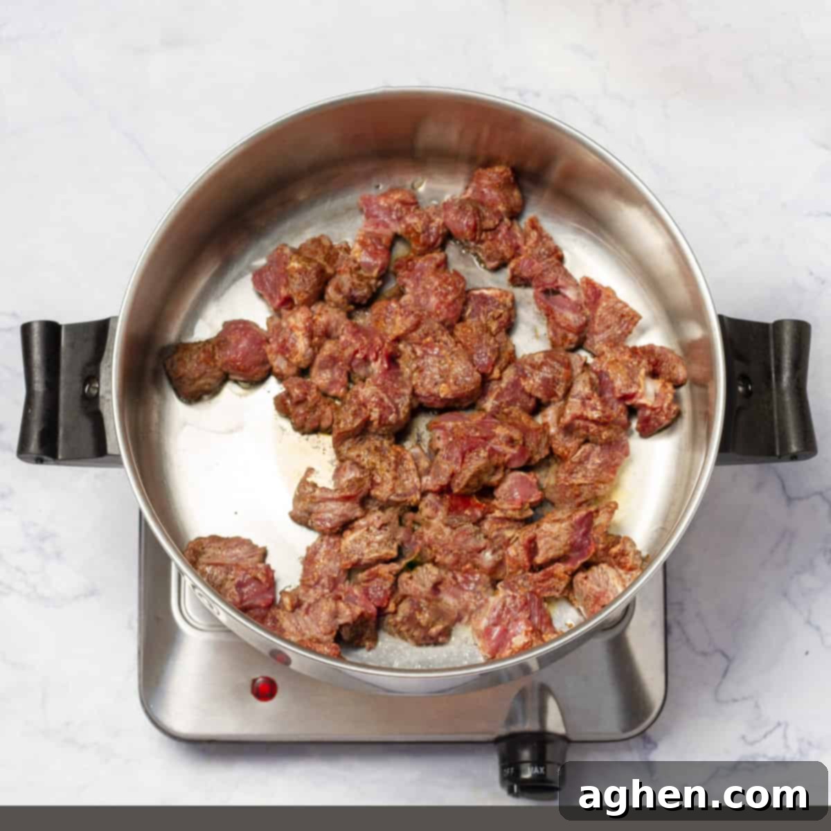 Browned beef cubes searing in hot oil in a large pot