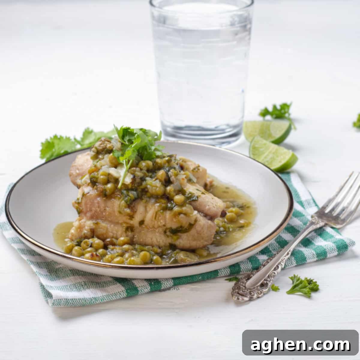 Romantik Akşamların Yıldızı: Yeşil Soslu Berlam 9 Hake in Green Sauce plated beautifully with a glass of water and crusty bread