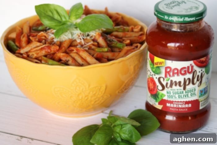 Whole wheat pasta with asparagus and marinara sauce served in a bowl, ready to enjoy.