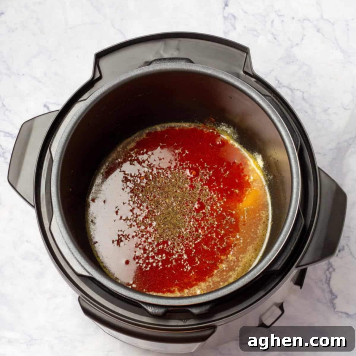 Juicy Instant Pot Pork Chops in Minutes 5 Chicken broth, garlic powder, onion powder, dried thyme, and smoked paprika being added to an Instant Pot after searing.