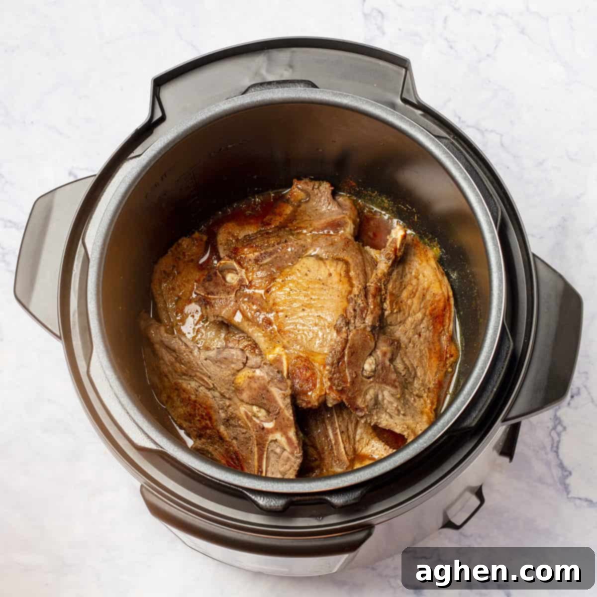 Juicy Instant Pot Pork Chops in Minutes 6 Pork chops cooking in an Instant Pot with the lid sealed.