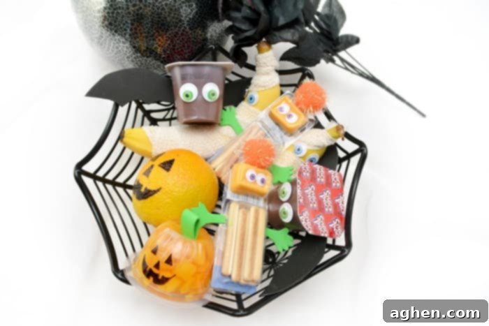 A vibrant collection of easy, non-candy Halloween snacks for kids, including mummy bananas, bat pudding cups, and monster cheese crackers, ideal for lunchboxes and parties.