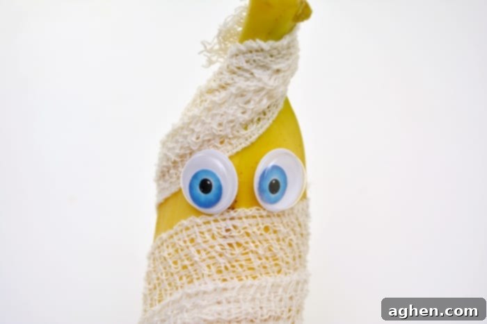 A finished spooky mummy banana Halloween snack, wrapped in gauze with googly eyes, ready for a kid's lunchbox or party.