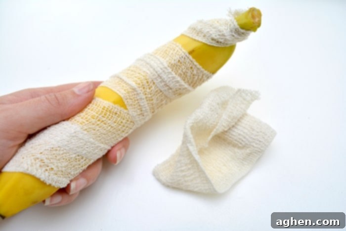 Step-by-step image showing how to wrap a banana with gauze to create a healthy Halloween mummy snack.