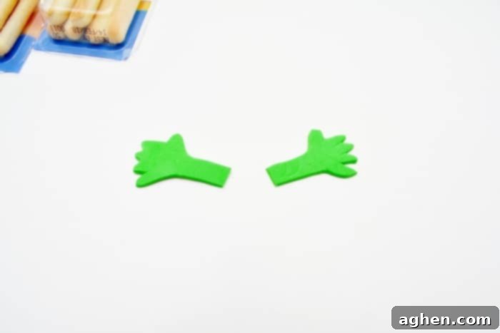 Close-up of a finished Halloween monster snack made from a cheese and cracker package, showing the attached craft foam arms.