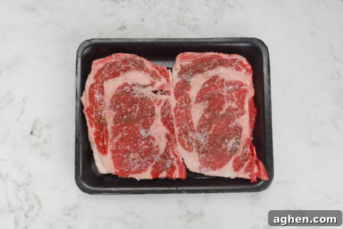 Mastering Steak on the Blackstone Griddle 4 raw ribeye, seasoned with salt and pepper