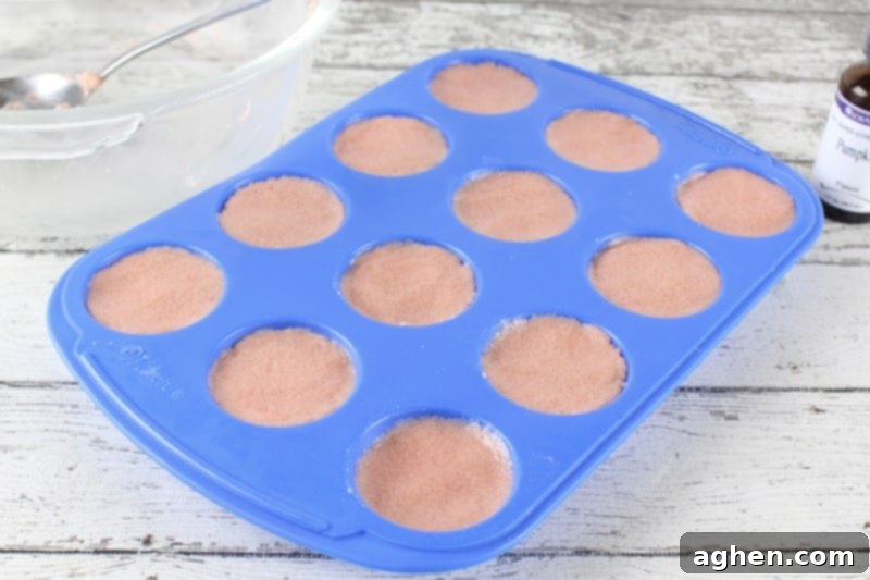 Silicone mini muffin pan filled with pumpkin spice bath bomb mixture
