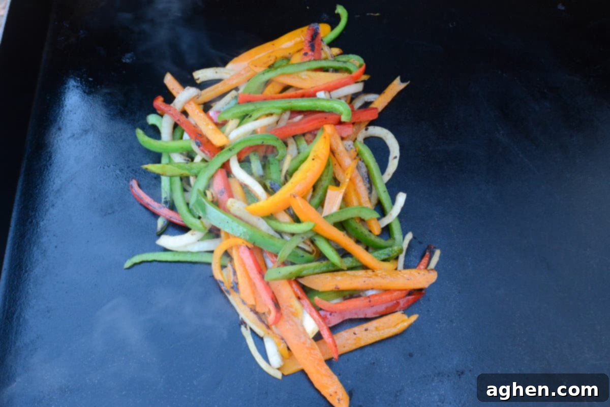 Vegetables have been scooped together into a pile. They are deeper in color, appear softer with some small charred bits