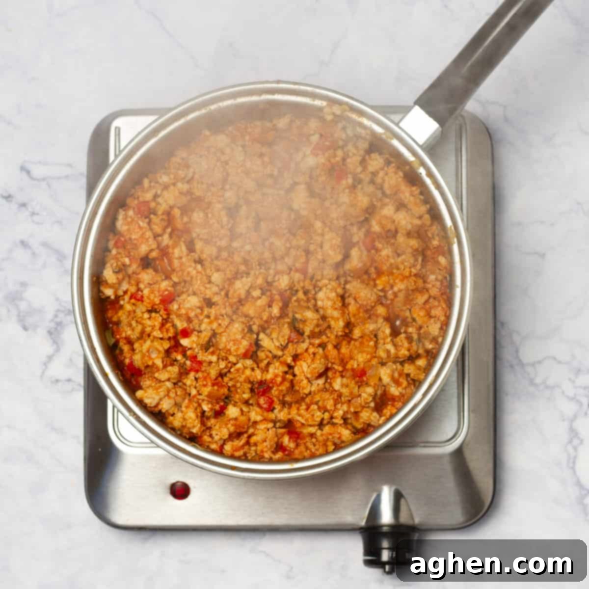 In a skillet cooking ground chicken