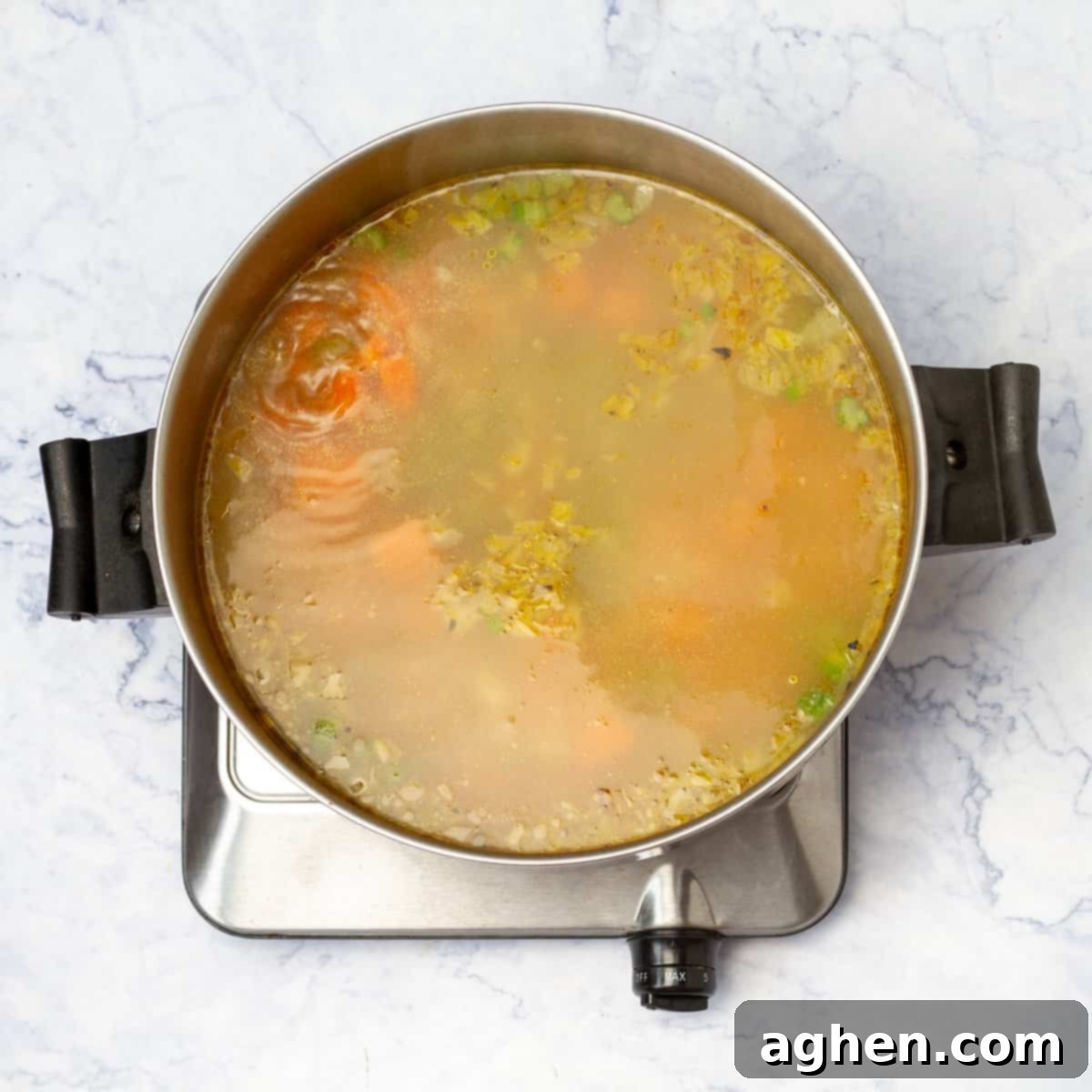 chicken broth poured into the pot of cooked vegetables