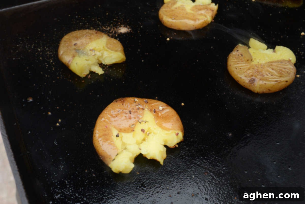 Crispy Blackstone Smashed Potatoes 10 smashed potatoes on blackstone sprinkled with seasonings