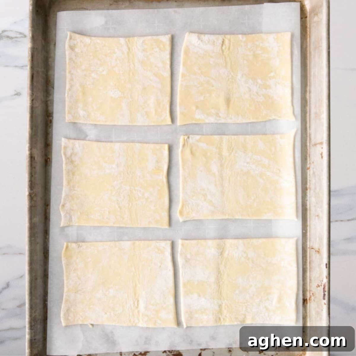 Cut puff pastry dough squares laid out, ready to be filled for spinach hand pies.