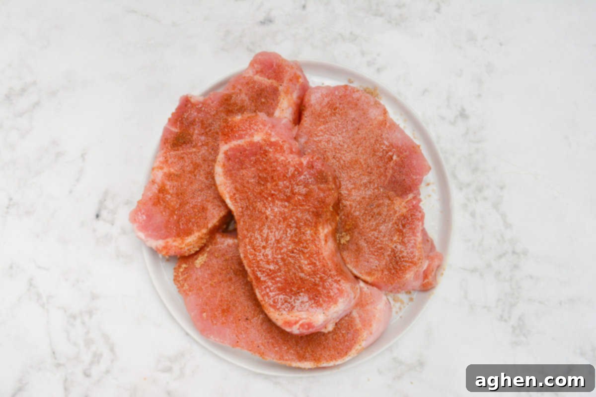 Blackstone'da Domuz Pirzolası 7 Kolay Adımda 7 raw pork chops generously seasoned with the homemade dry rub