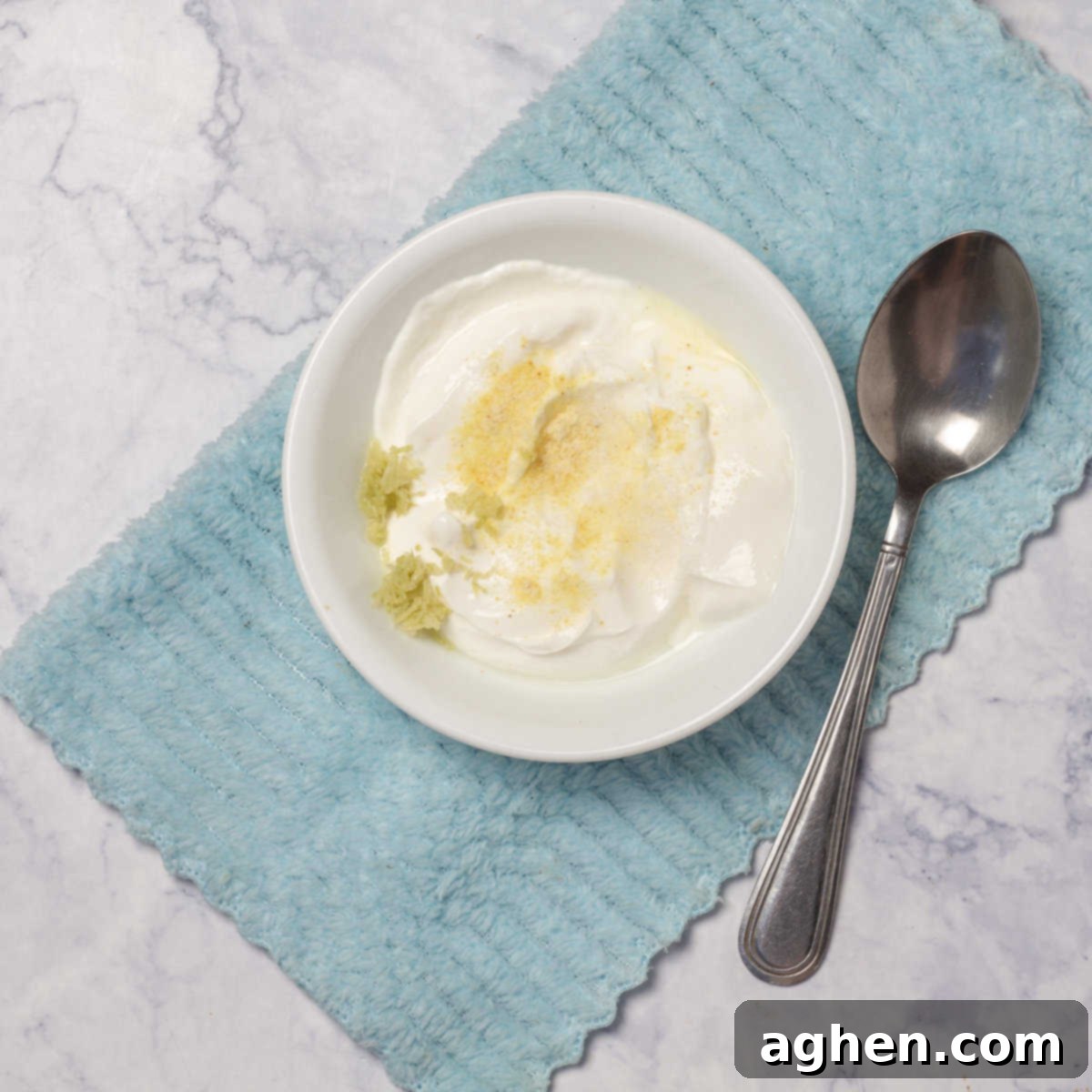 Prepare the yogurt cream by mixing plain Greek yogurt, minced garlic, lemon zest, and salt in a small bowl.