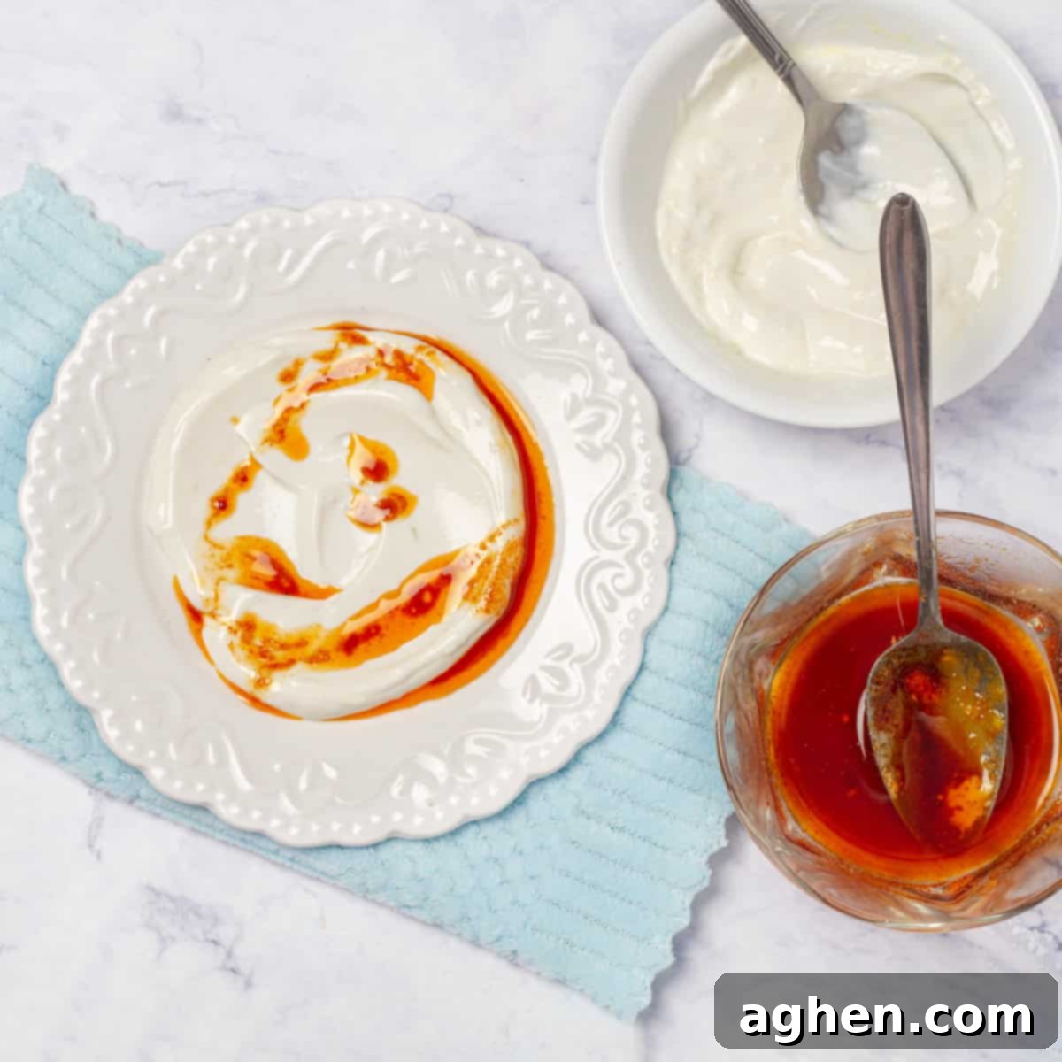 Drizzle the lemon-garlic yogurt mixture with the warm paprika butter sauce before adding the poached eggs on top.