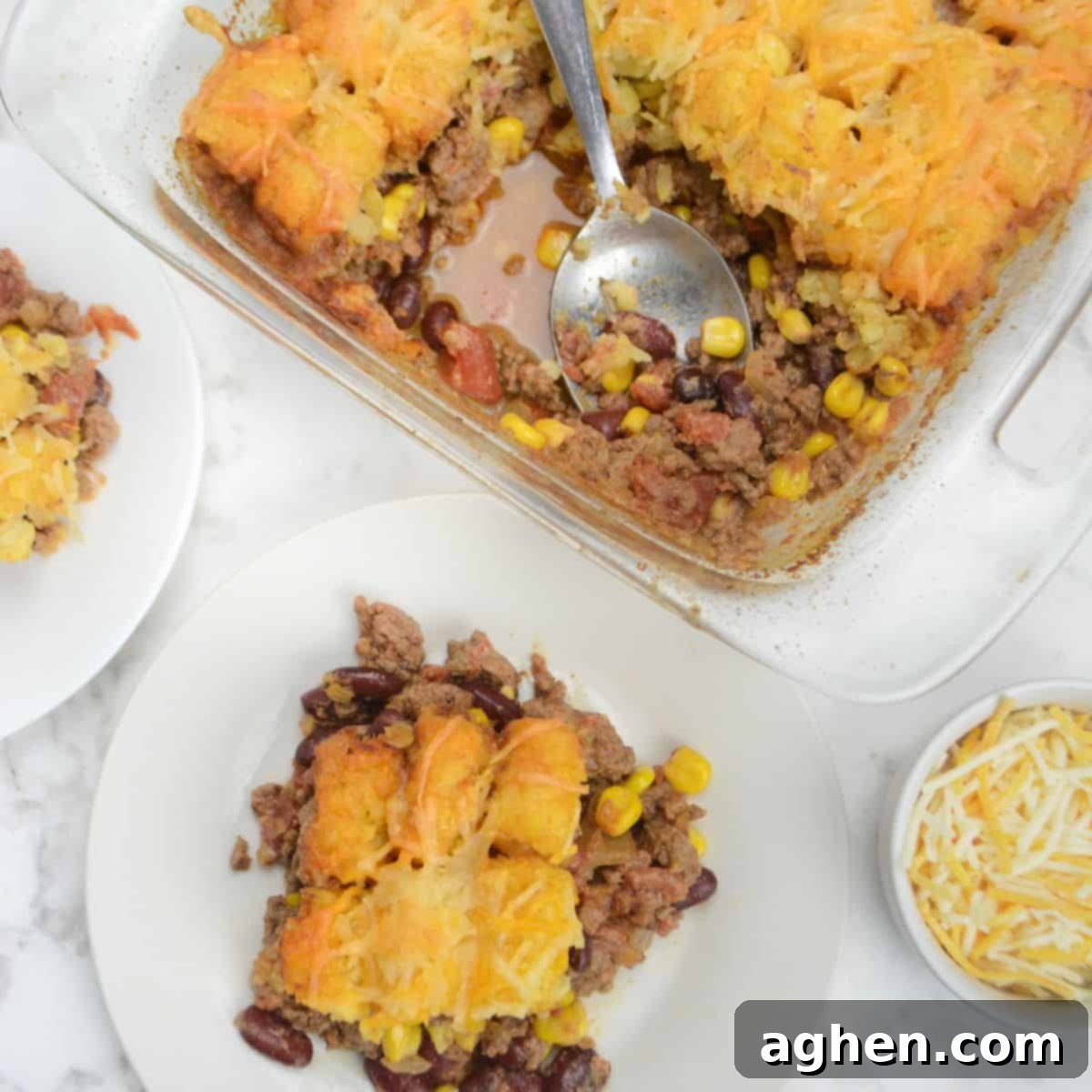 Guilt-Free Cowboy Casserole: A Weight Watchers Recipe You'll Love 2 A casserole dish is shown with two servings plated underneath. A small bowl of cheese sits to the side.