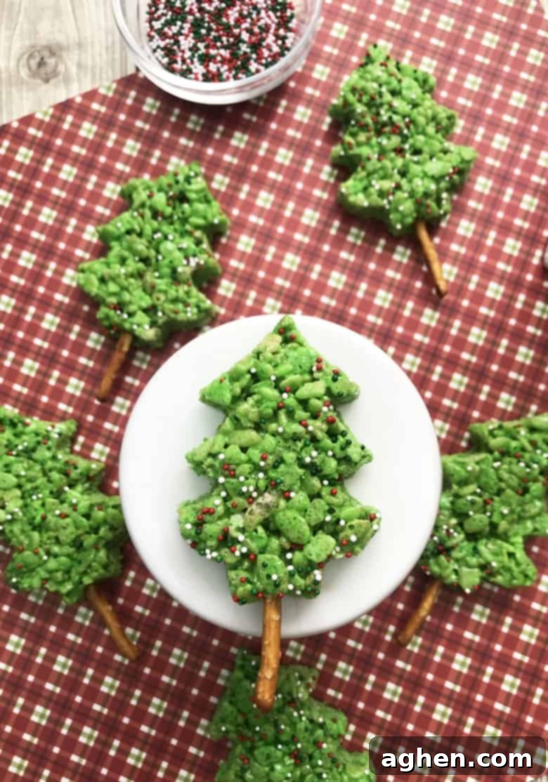 A vibrant green Rice Krispie Treat shaped like a Christmas tree, adorned with festive sprinkles