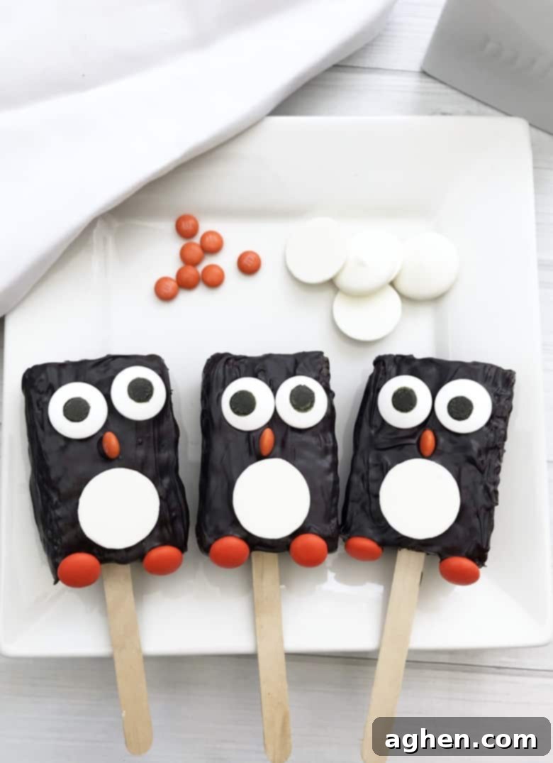 These adorable penguin Rice Krispie Treats take minutes to make using store-bought Rice Krispie Treats, candy melts, and a few candies.
